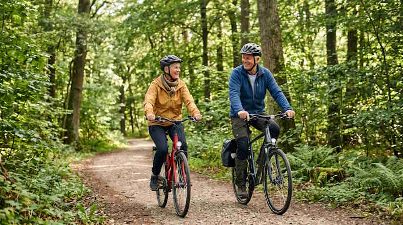 Aktivt dansk par over 55 på cykeltur i skoven